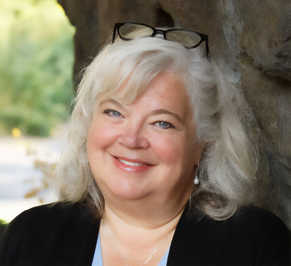 二人の人物が温室の中で植物を調べている。