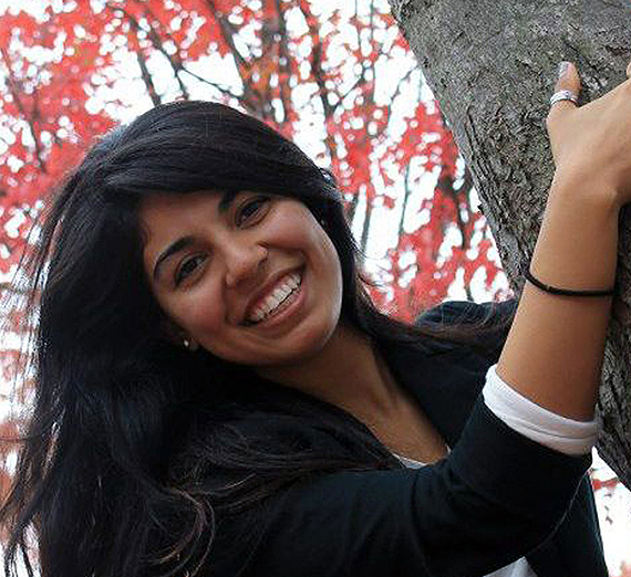 女性が窓の横で腕を組んで立っている