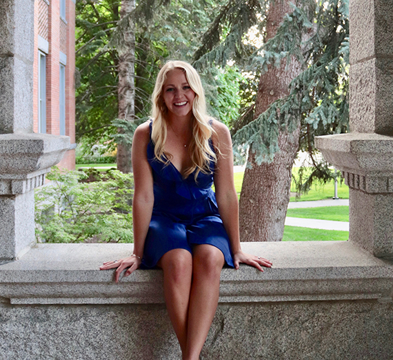 女性が窓の横で腕を組んで立っている